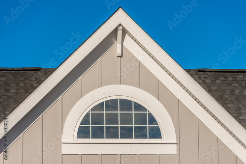Tableau sur toile Half round decorative attic window with white grilles on desert tan vertical lap