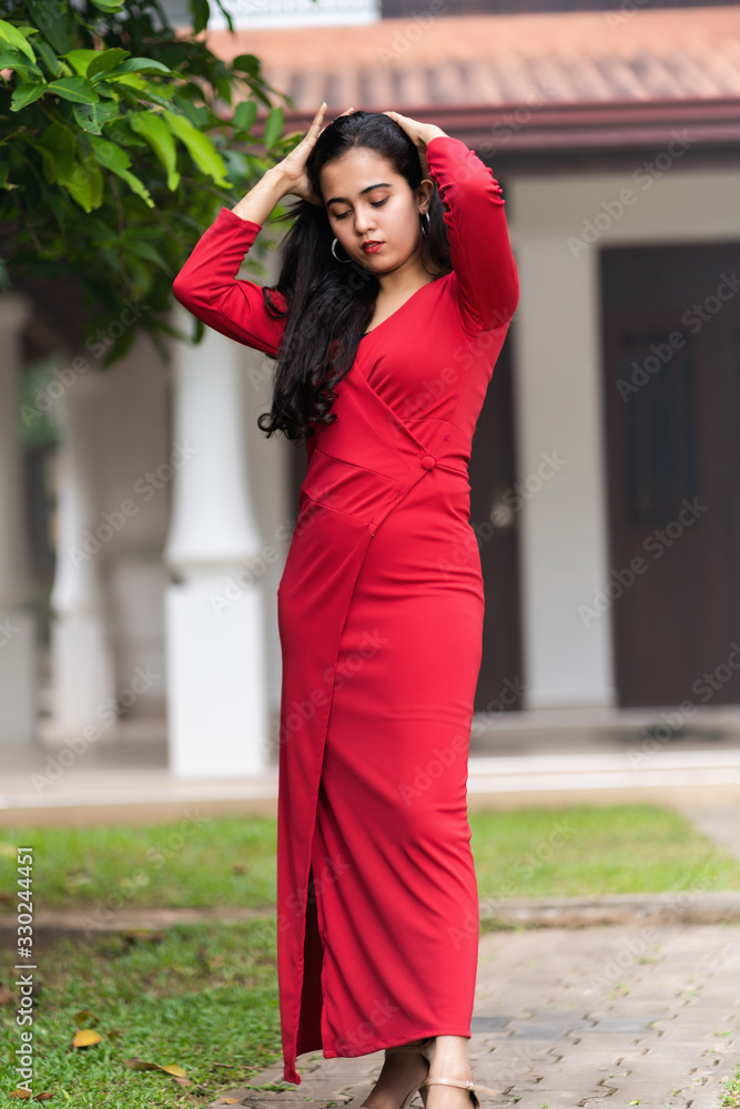 fashion outdoor photo of beautiful woman in luxurious red dress posing