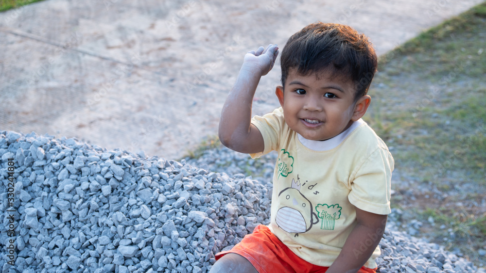 Cute little asian little boy play on the Stone pile Cute little asian little boy play on the Stone pile