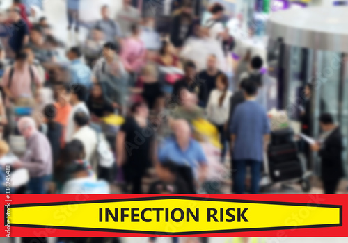 Blurred airport background with a crowd of people moving through the terminal. A banner warns of the risk of infection.