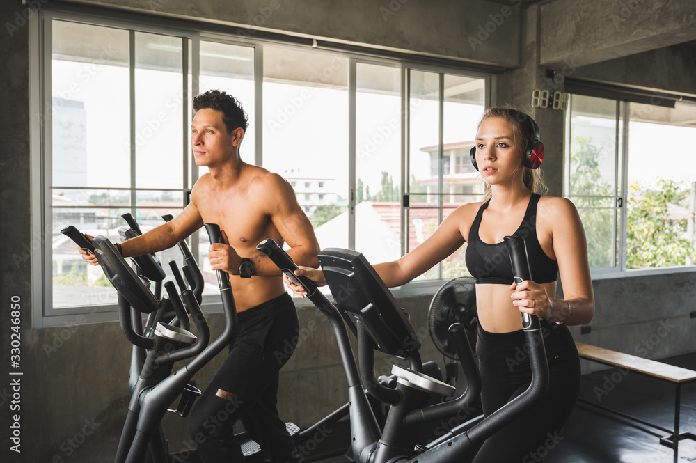 Group of people at the gym exercising on the cross trainer machine. Young fitness men and women doing cardio workout program for beginner. Group of people at the gym exercising on the cross trainer machine. Young fitness men and women doing cardio workout program for beginner.