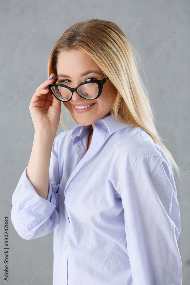 Portrait of a sexy woman in a man's shirt wearing glasses on a gray background looks at the camera and smiling look advice to give wants objections are not accepted Portrait of a sexy woman in a man's shirt wearing glasses on a gray background looks at the camera and smiling look advice to give wants objections are not accepted