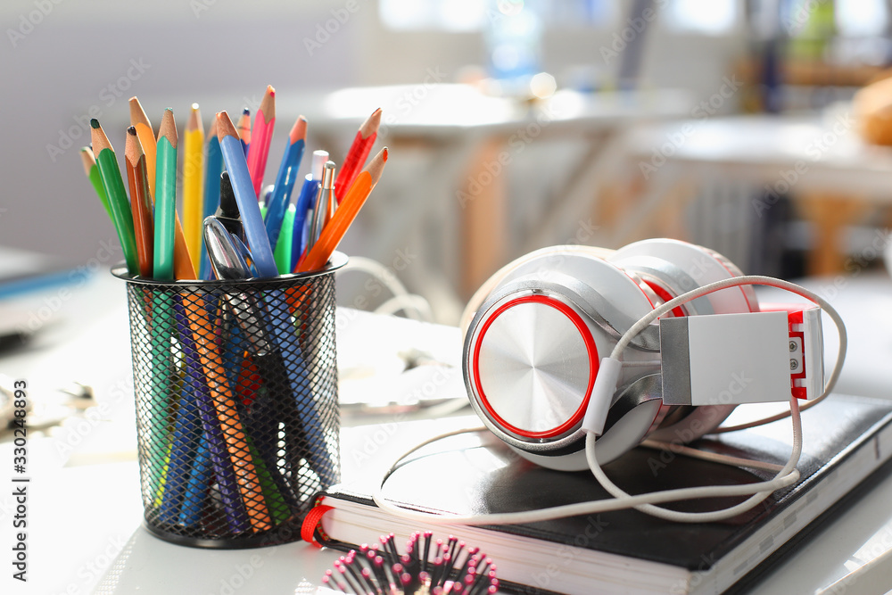 Headphones diary and pencil lie on the desk of the concept of remote distance education listen to music compose tunes for sale school sound training instruments thematic studing sound recording studio