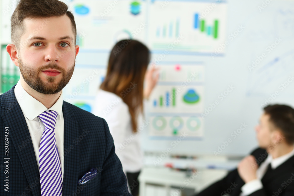 Young handsome teacher man in suit with workgroup seminar board with chart coaching background. Lecturer for applicants retraining financial statistics management enterprise etiquette corporate spirit Young handsome teacher man in suit with workgroup seminar board with chart coaching background. Lecturer for applicants retraining financial statistics management enterprise etiquette corporate spirit
