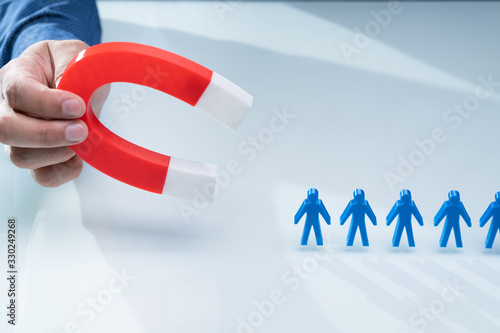Businessman Attracting Blue Team With Horseshoe Magnet