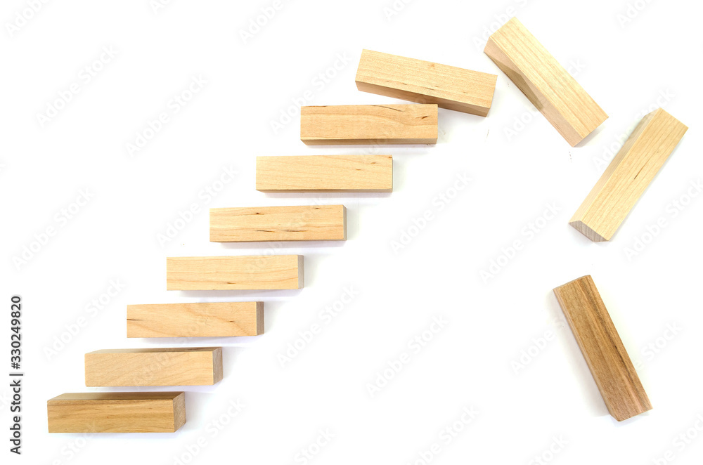 Close up wooden block with a business risk management concept.Falling wooden blocks on a white background. Close up wooden block with a business risk management concept.Falling wooden blocks on a white background.