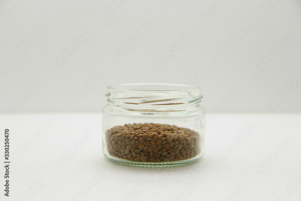 Glass jar with lentils on a white background, side view. Glass jar with lentils on a white background, side view.