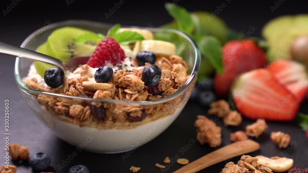 Scooping Yogurt with granola and fruits . Scooping Yogurt with granola and fruits .