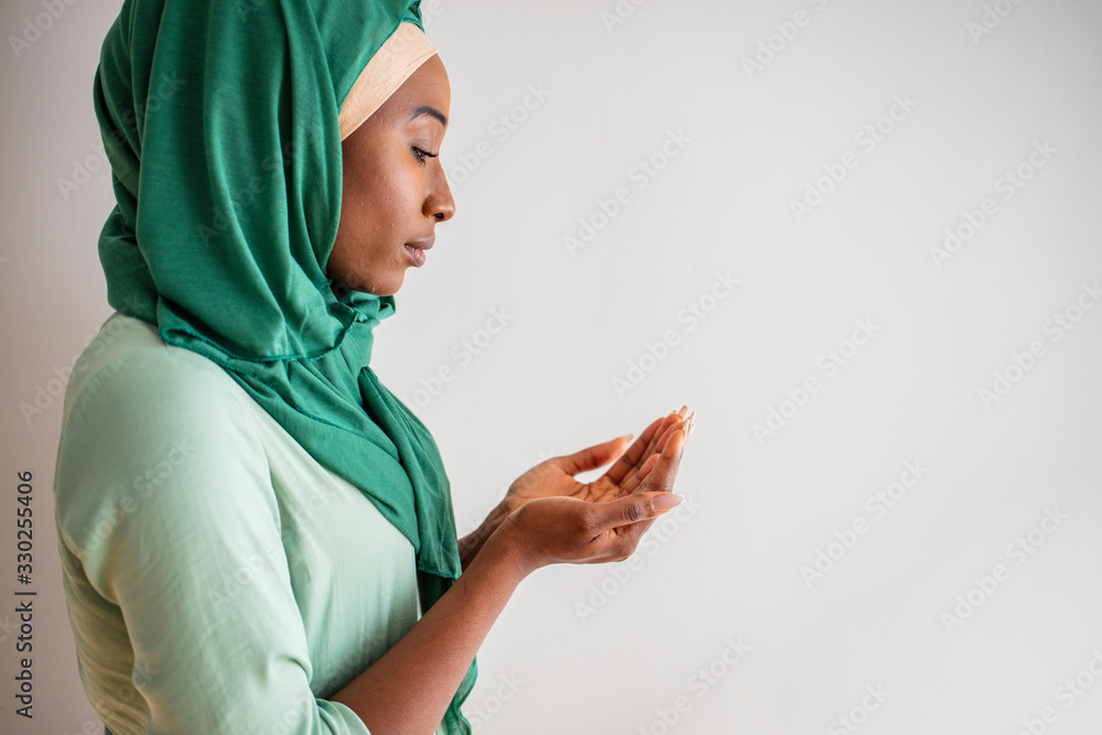 Young muslim woman in green hijab and traditional clothes praying for ...