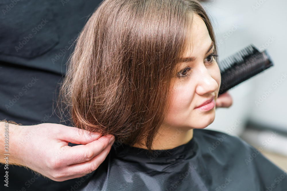 Fototapeta premium Hairdresser combs hair.