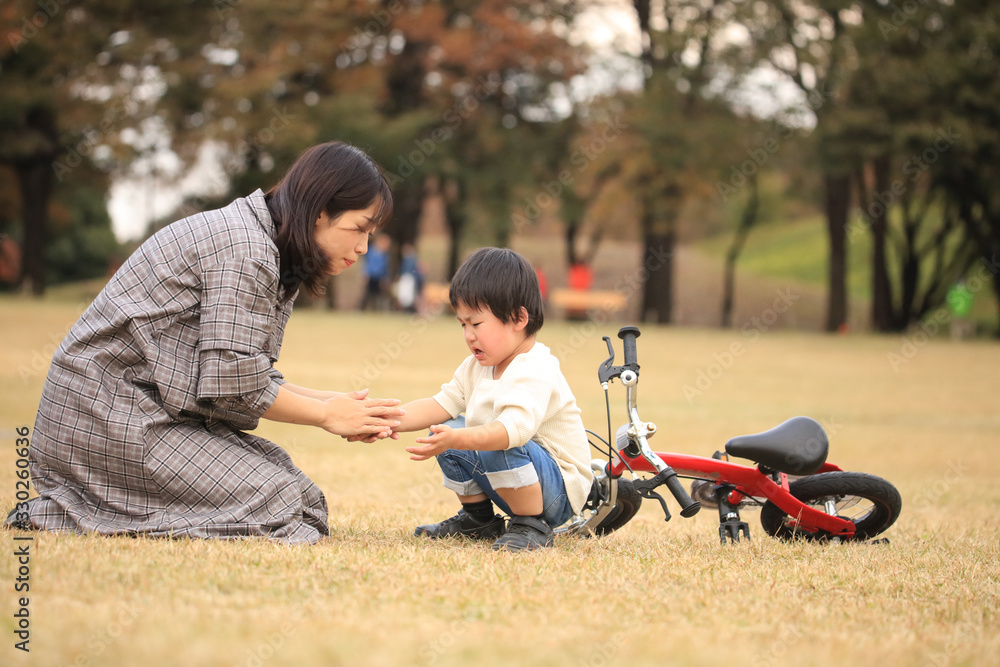 Fototapeta premium 自転車に乗る練習中に転んだ男の子