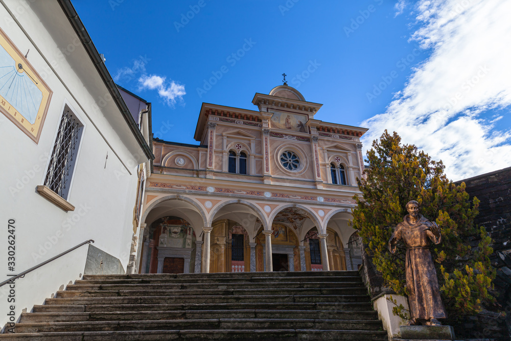 Close up front view of Madonna del Sasso church above Locarno city oa sanctuary and pilgrimage church in Orselina, in autumn on sunny day with blue sky cloud, Canton of Ticino, Switzerland