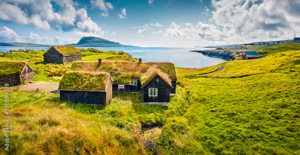 Sunny morning view of typical turf-top houses. Panoramic summer scene of outskirts of Torshavn city, capital of Faroe Islands, Kingdom of Denmark, Europe. Traveling concept background.. - obrazy, fototapety, plakaty 