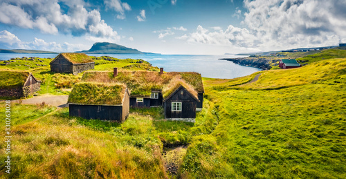 Sunny morning view of typical turf-top houses. Panoramic summer scene of outskirts of Torshavn city, capital of Faroe Islands, Kingdom of Denmark, Europe. Traveling concept background..