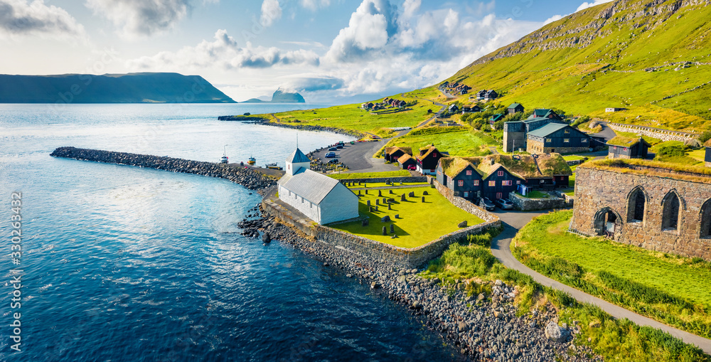 View from flying drone. Aerial summer view of Kirkjubour villagewith Hestur Island on background. Picturesque morning scene of Faroe Islands, Denmark, Europe.  Beauty of nature concept background. - obrazy, fototapety, plakaty 