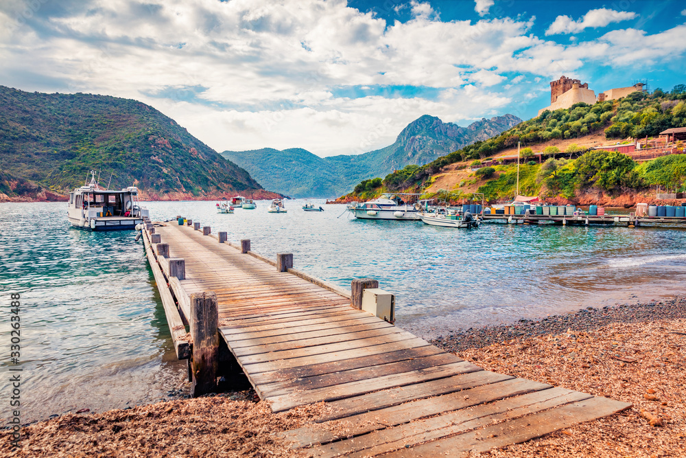 Old wooden pier in Port de Girolata - place, where you can't get by car. Sunny summer scene of Corsica island, France, Europe. Beautiful Mediterranean seascape. Traveling concept background.. Old wooden pier in Port de Girolata - place, where you can't get by car. Sunny summer scene of Corsica island, France, Europe. Beautiful Mediterranean seascape. Traveling concept background..