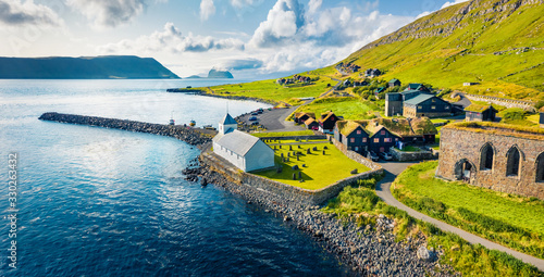 View from flying drone. Aerial summer view of Kirkjubour villagewith Hestur Island on background. Picturesque morning scene of Faroe Islands, Denmark, Europe.  Beauty of nature concept background.