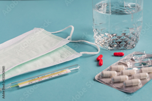 Virus Pandemic treatment. Medicines, capsules, thermometer and protective masks. Healthcare concept. photo