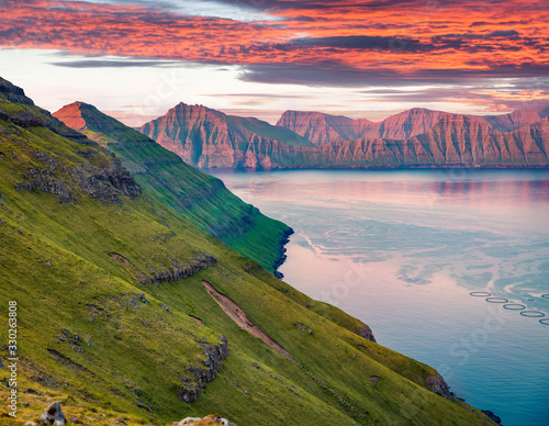 Exciting summer sunset on Faroe Islands, Denmark, Europe. Last sunlight glowing mountain ridge. Beauty of nature concept background.