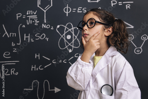 Foto pensive little girl science student in lab coat