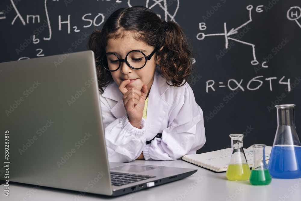 little scientist girl looking to the computer
