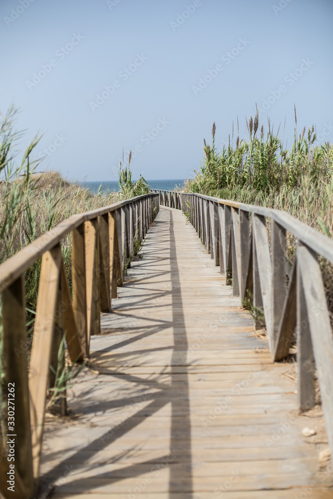 puente de madera que hace de pasarela al mar mediterráneo