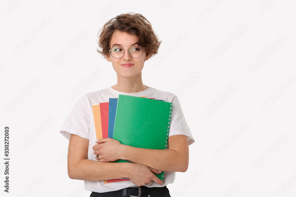 Female student in a white shirt and eyeglasses holding colorful folders Female student in a white shirt and eyeglasses holding colorful folders