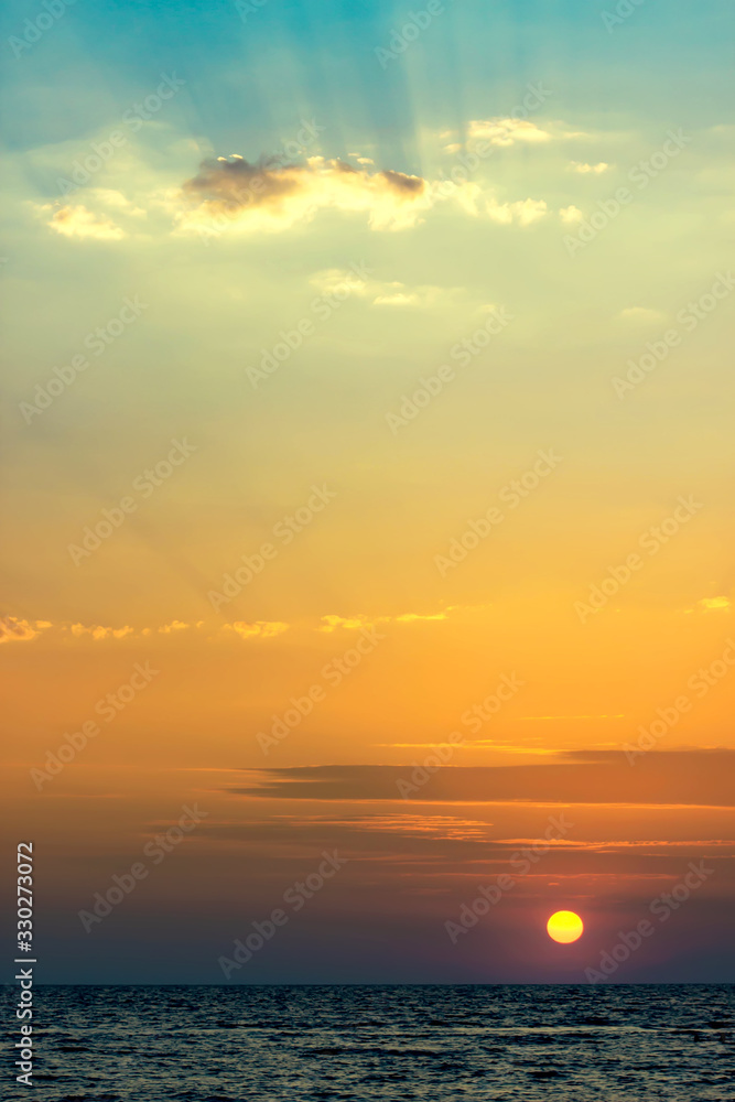 Beautiful summer sunset on the sea. Delicate sunset colors. Vertical view.