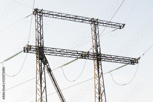 Supports high-voltage power lines against the blue sky