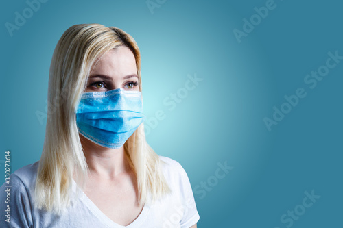 an attractive young woman wears a paper face mask to protect herself from the Virus photo
