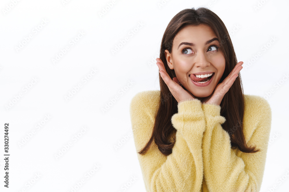 Coquettish feminine silly beautiful woman in yellow sweater, grinning and showing tongue flirty, dreamy gazing upper left corner as telling her secret to friend and being shy from love and happiness Coquettish feminine silly beautiful woman in yellow sweater, grinning and showing tongue flirty, dreamy gazing upper left corner as telling her secret to friend and being shy from love and happiness
