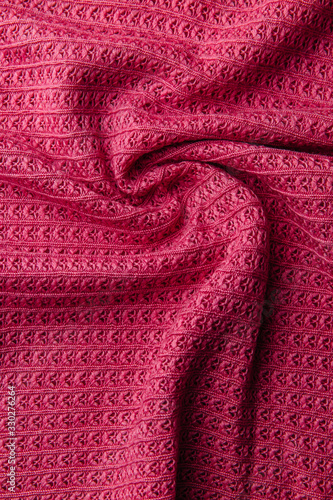 Pink wool knitted fabric texture. Wrinkled background of fabric.