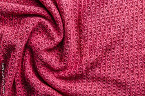 Pink wool knitted fabric texture. Wrinkled background of fabric.