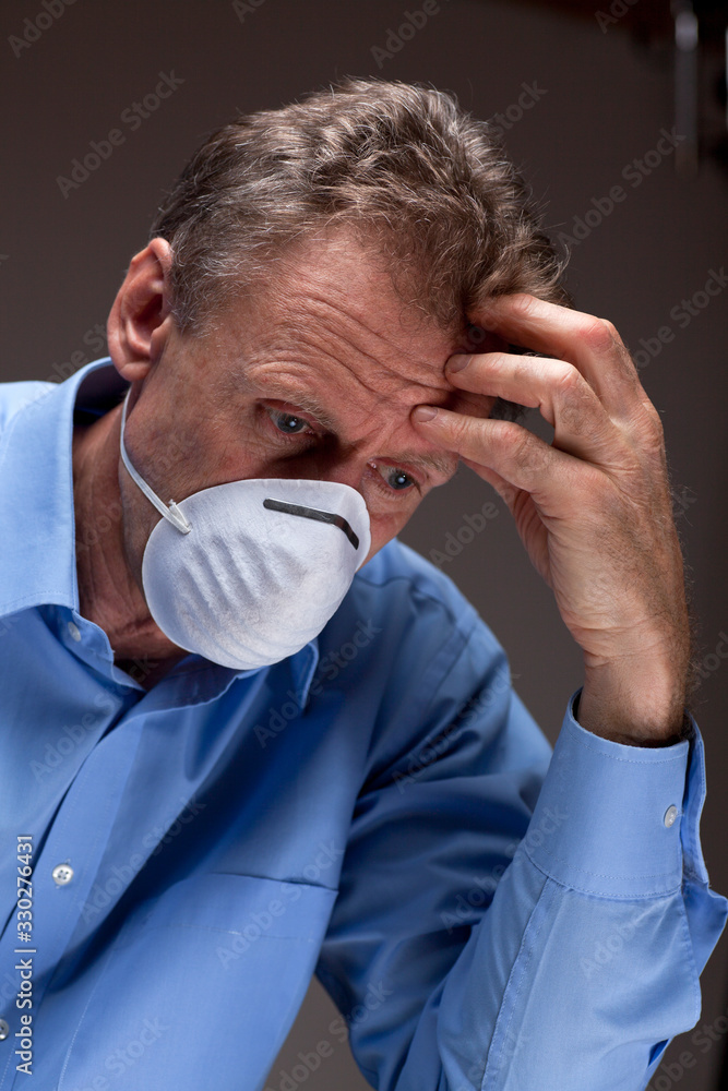 Thoughtful worried physician with medical mask in a hospital Thoughtful worried physician with medical mask in a hospital