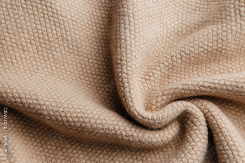Brown wool knitted fabric texture. Wrinkled background of fabric.