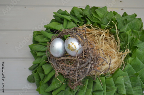 Wreath of green leaves with silver eggs in the nest. easter plants