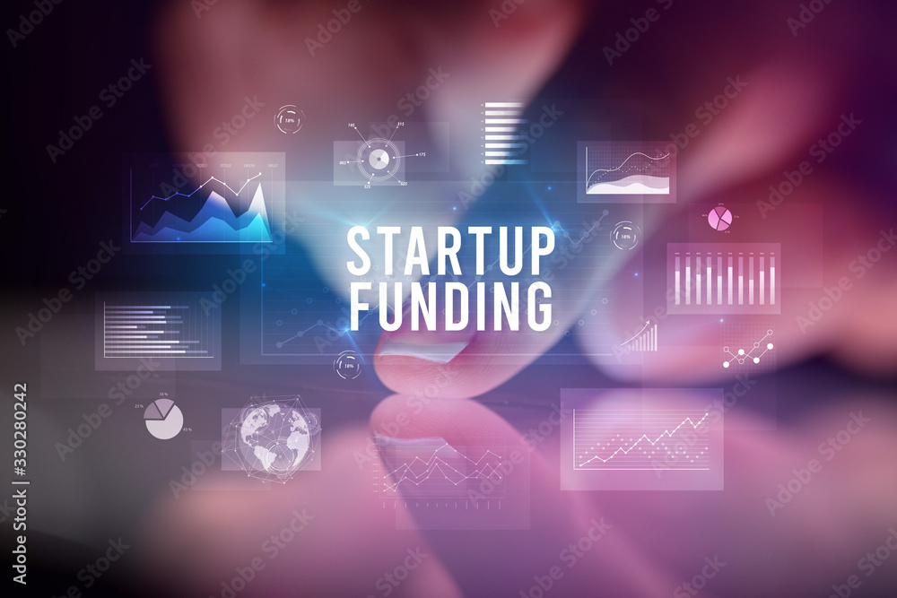 Finger touching tablet with charts and STARTUP FUNDING inscription, business concept Finger touching tablet with charts and STARTUP FUNDING inscription, business concept