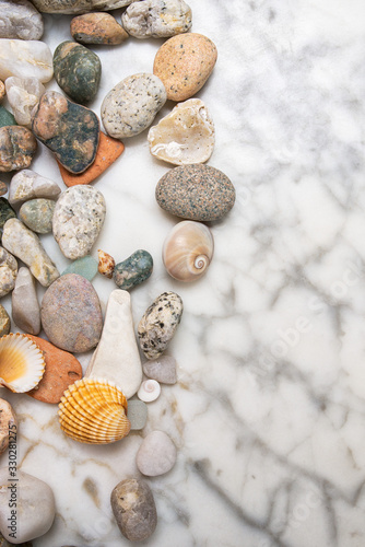 star  stones and shells lying on a marble background  vertical composition of sea stones and seashells  marine composition  composition of seashells  starfish  jellyfish  