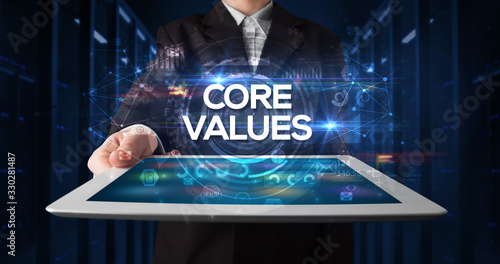 Young business person working on tablet and shows the inscription: CORE VALUES, business concept