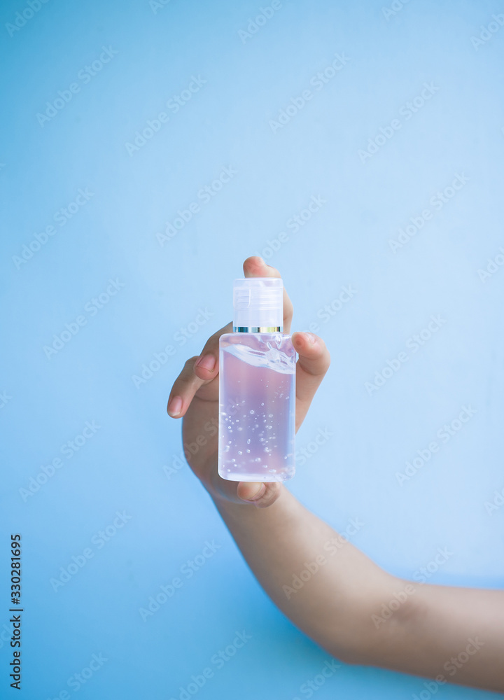 one women hand is carrying alcohol gel for washing hands to protect ...