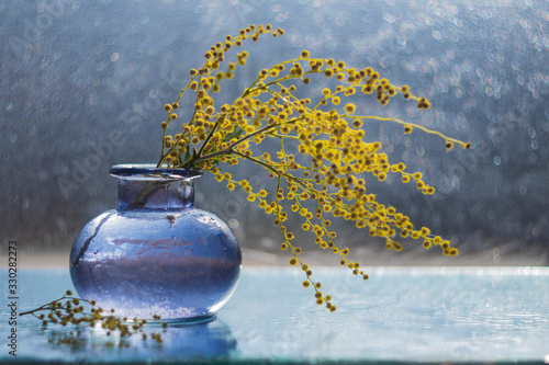 bouquet of flowers in vase on blue background