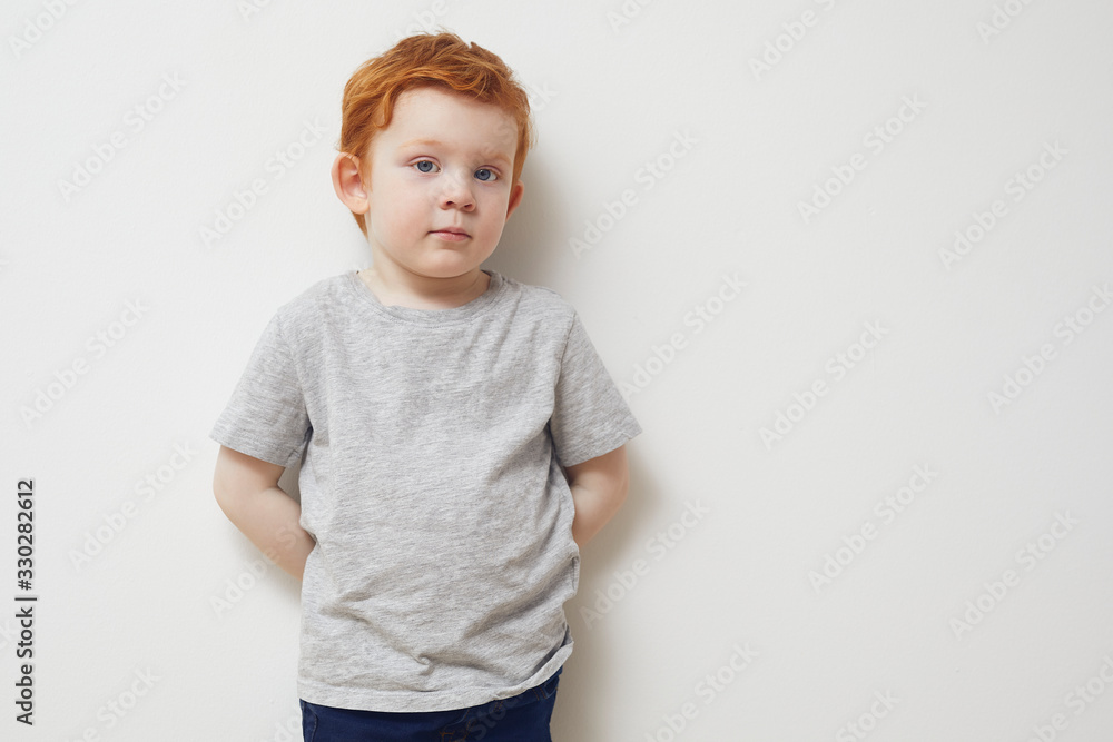 Portrait of redhead boy standing agianst a white wall Portrait of redhead boy standing agianst a white wall