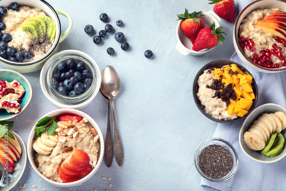 Bowls of oatmeal with berries and fruits for healthy breakfast. Food with vitamins, minerals and antioxidants. Top view with copy space Bowls of oatmeal with berries and fruits for healthy breakfast. Food with vitamins, minerals and antioxidants. Top view with copy space