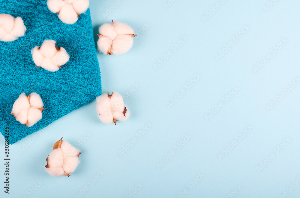 Spa concept idea, cotton and towel composition on blue background.