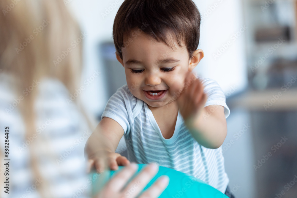 Happy baby smiling while having fun with blue ball at home. Happy baby smiling while having fun with blue ball at home.