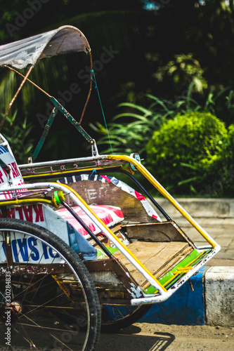 Indonesian Traditional Transportation - Becak (Tuk-Tuk) or Cycle Rickshaw, waiting for customers photo