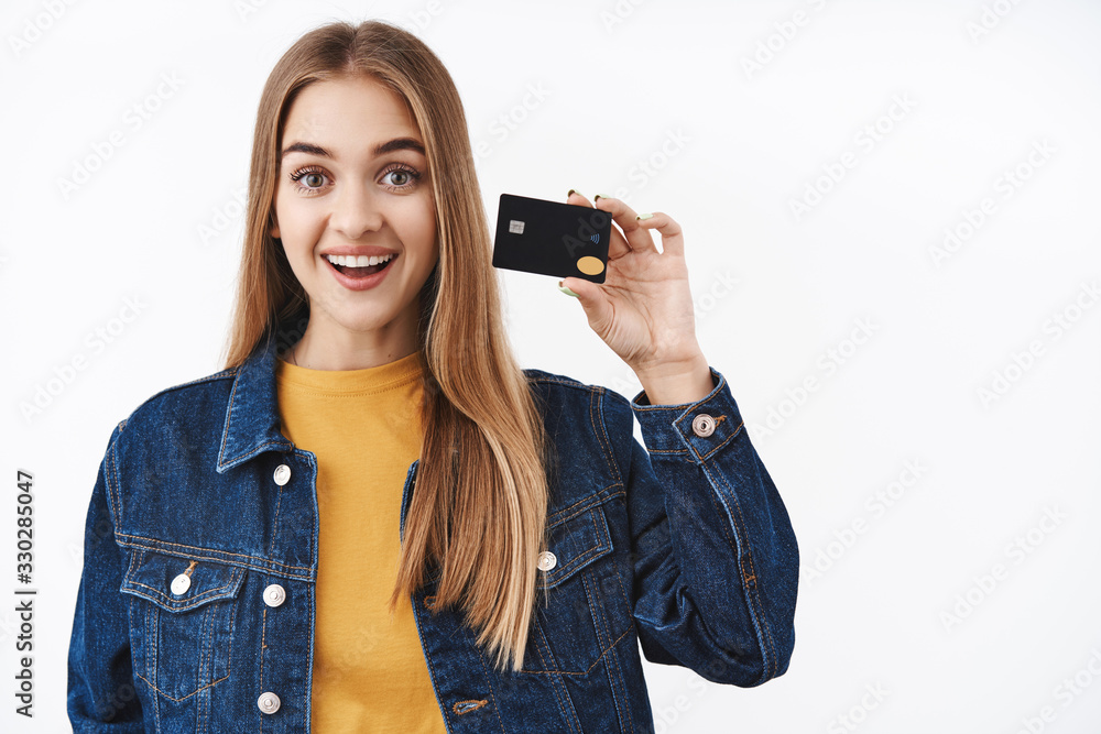 Girl likes paying without cash, using credit card for online purchase, travel light, holding banking card and smiling broadly as recommend company service, explain new features, white background Girl likes paying without cash, using credit card for online purchase, travel light, holding banking card and smiling broadly as recommend company service, explain new features, white background