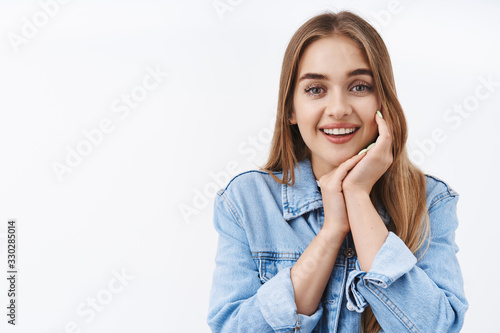 Cute girl look at adorable kitten. Close-up portrait charming young woman with blond hair, sighing tenderly smiling and contemplate something beautiful, touch cheek gently, white background