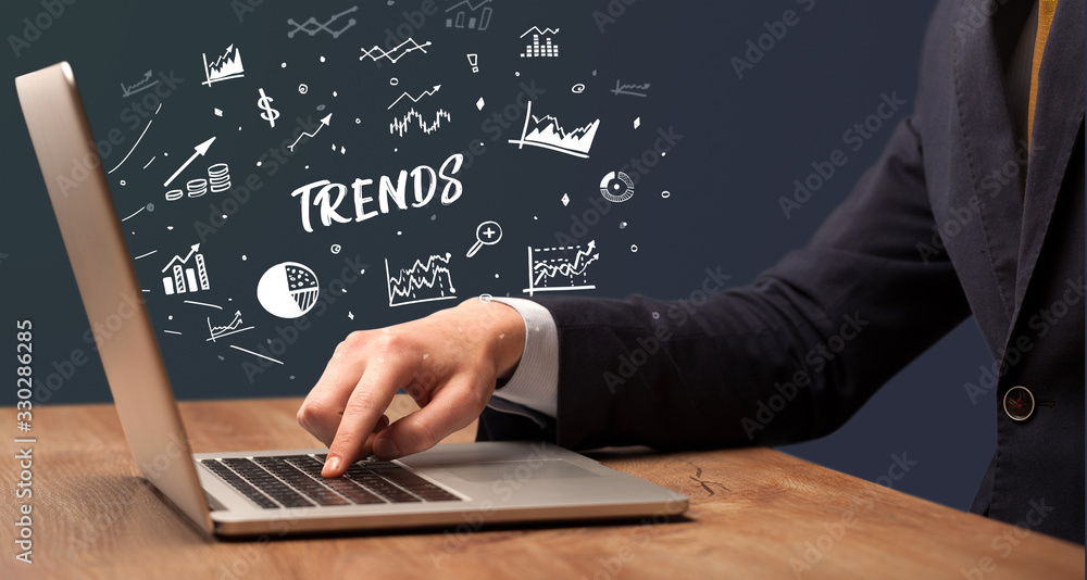 Businessman working on laptop with TRENDS inscription, modern business concept Businessman working on laptop with TRENDS inscription, modern business concept