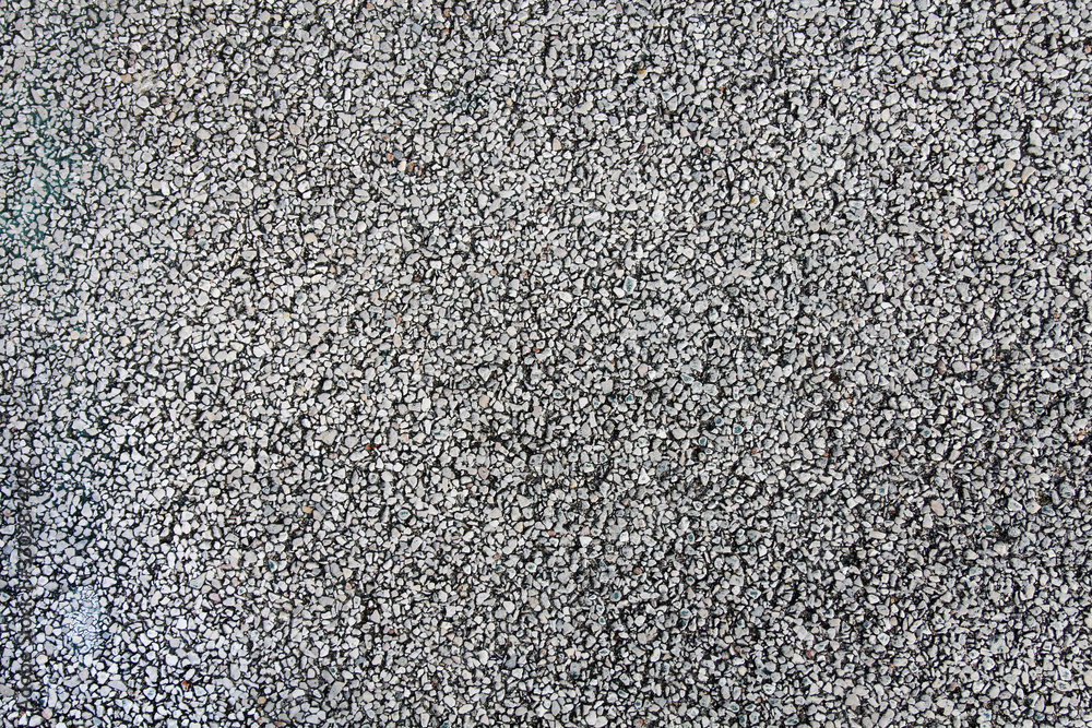 Gray asphalt with white pebbles on urban soccer field Gray asphalt with white pebbles on urban soccer field